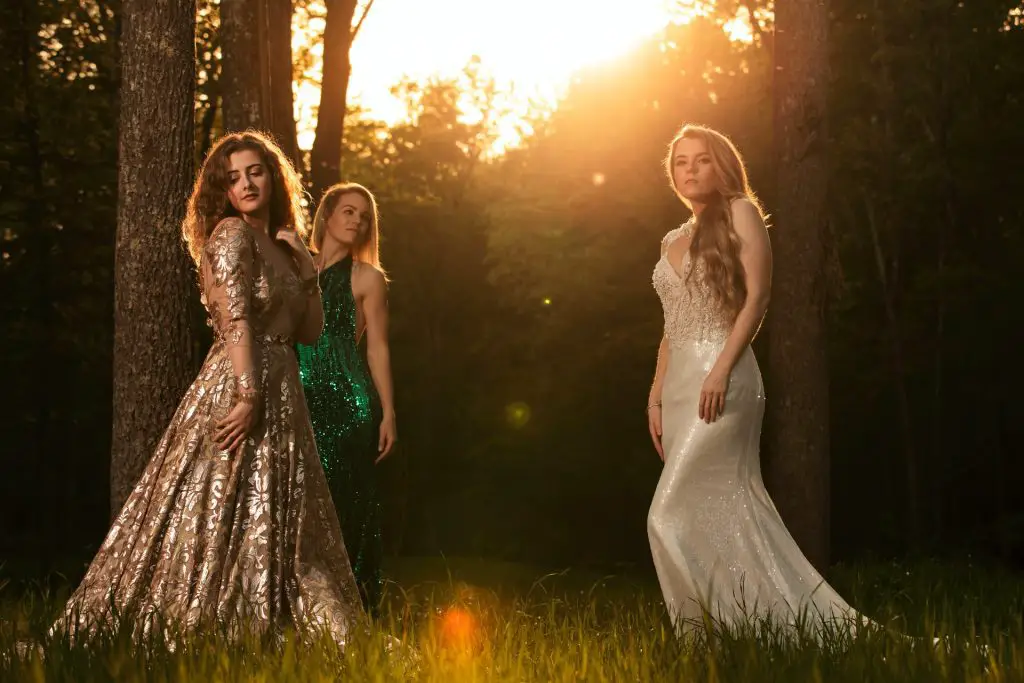 Three women  wearing maxi dresses posing in nature