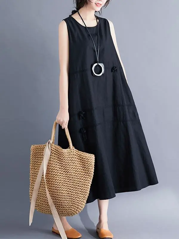 A woman wearing a black maxi dress ad carrying a statement bag