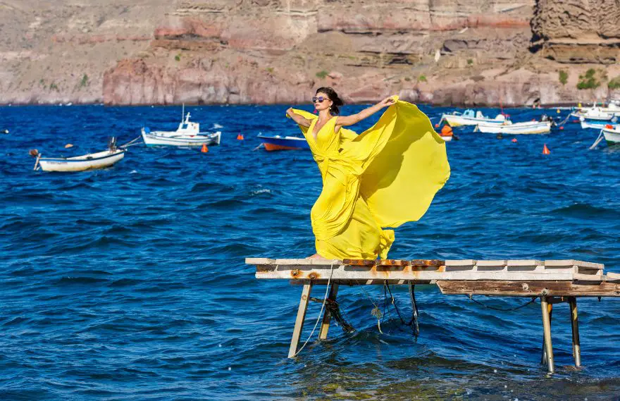 A woman wearing a yellow maxi dress on the docks